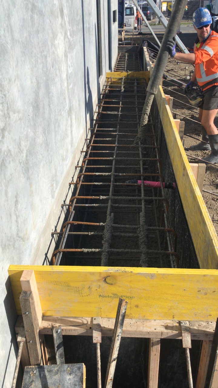 concrete being poured by a construction worker